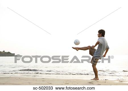 Young Man Playing Soccer On A Beach View Large Photo Image Stock Image - Young Man Playing Soccer On A Beach. Fotosearch