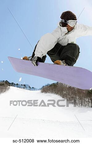Stock Photo - Young snowboarder mid air. Fotosearch