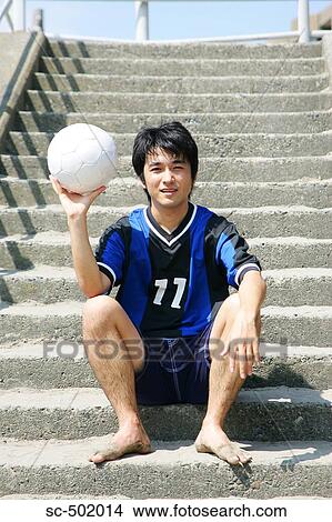 Picture - Young Soccer Player Sitting On a Flight of Stairs. Fotosearch