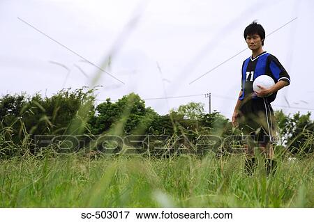 Stock Photo - Young Soccer Player Standing In a Field. Fotosearch
