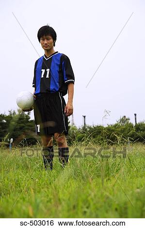 Stock Photograph - Young Soccer Player Standing In a Field. Fotosearch
