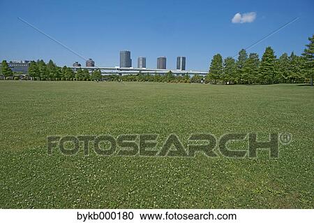Stock Image - Urban park and blue sky with clouds. Fotosearch