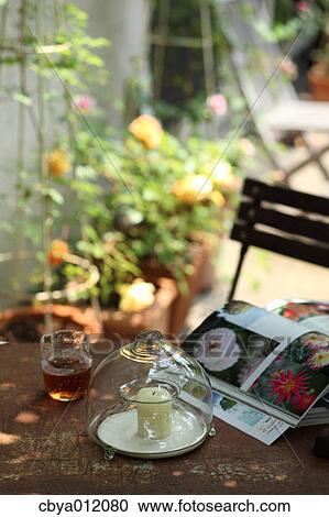 Candle drink and books on an outdoor table View Large Photo Image Stock Image - Candle drink and books on an outdoor table. Fotosearch