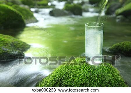 Glass of water near a mountain stream View Large Photo Image Stock Image - Glass of water near a mountain stream. Fotosearch