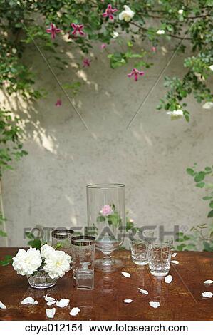Glasses and flowers on a table in the garden View Large Photo Image Picture - Glasses and flowers on a table in the garden. Fotosearch