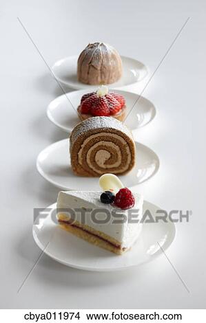 Picture - Mixed cakes in a row on a table. Fotosearch