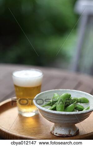 Soybeans and beer on a wooden plate View Large Photo Image Stock Photo - Soybeans and beer on a wooden plate. Fotosearch