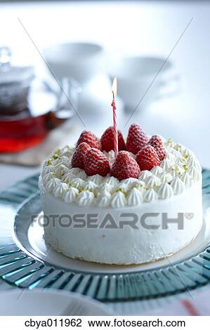 Stock Image - Strawberry shortcake with candle on a glass plate. Fotosearch