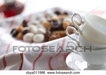 Tea cups and assorted pastry in the background View Large Photo Image Stock Photograph - Tea cups and assorted pastry in the background. Fotosearch