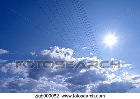 Stock Image - Transmission lines and blue sky with clouds. Fotosearch