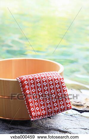 Stock Photo - Cloth and tub at open-air hot springs. Fotosearch