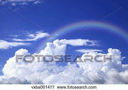 Stock Photo - Blue sky with clouds and rainbow. Fotosearch