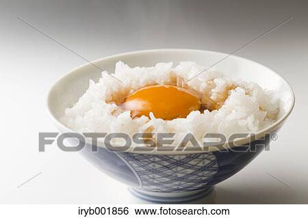 Stock Photograph - Raw egg on rice. Fotosearch