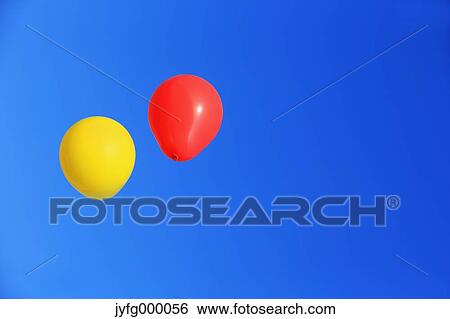 Stock Photograph - Balloons flying in the blue sky. Fotosearch