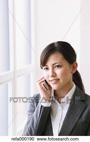 Businesswoman on the phone by the window View Large Photo Image Stock Image - Businesswoman on the phone by the window. Fotosearch