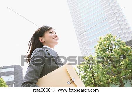 Businesswoman with envelope walking View Large Photo Image Stock Photo - Businesswoman with envelope walking. Fotosearch