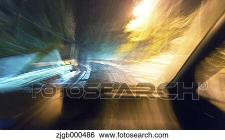 Stock Photograph - Car travelling through a snow storm. Fotosearch