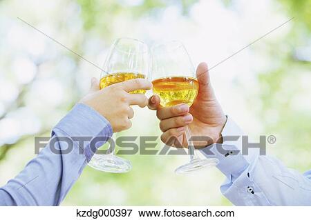 Couple cheering with white wine View Large Photo Image Stock Photo - Couple cheering with white wine. Fotosearch