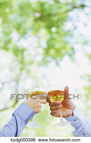 Stock Photo - Couple cheering with white wine. Fotosearch
