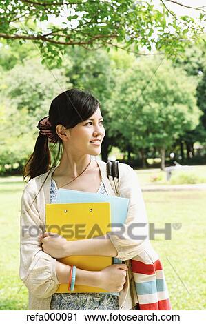 Female college student in a park smiling away View Large Photo Image Stock Image - Female college student in a park smiling away. Fotosearch