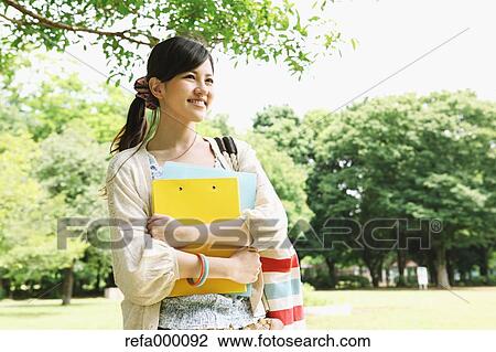 Female college student in a park smiling away View Large Photo Image Stock Image - Female college student in a park smiling away. Fotosearch