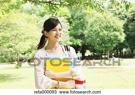 Female college student in a park smiling away View Large Photo Image Stock Image - Female college student in a park smiling away. Fotosearch