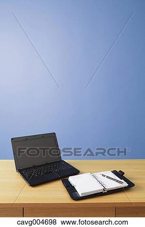 Laptop and agenda on wooden desk View Large Photo Image Stock Photo - Laptop and agenda on wooden desk. Fotosearch