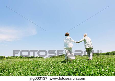 Senior couple on grassland holding hands View Large Photo Image Stock Photo - Senior couple on grassland holding hands. Fotosearch