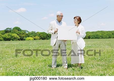 Senior couple on grassland holding whiteboard View Large Photo Image Stock Image - Senior couple on grassland holding whiteboard. Fotosearch