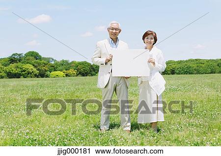 Senior couple on grassland holding whiteboard View Large Photo Image Stock Image - Senior couple on grassland holding whiteboard. Fotosearch
