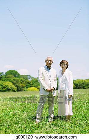 Senior couple on grassland smiling at camera View Large Photo Image Stock Photo - Senior couple on grassland smiling at camera. Fotosearch