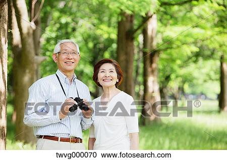 Senior couple with binoculars smiling away View Large Photo Image Stock Image - Senior couple with binoculars smiling away. Fotosearch