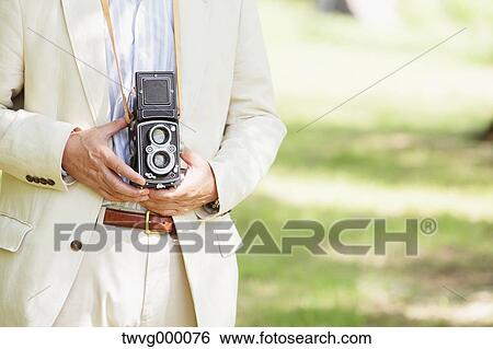 Stock Photograph - Senior man with vintage camera. Fotosearch