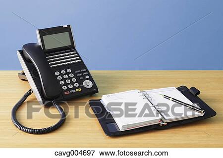 Telephone and agenda on wooden desk View Large Photo Image Stock Photo - Telephone and agenda on wooden desk. Fotosearch