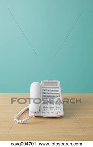Stock Image - Telephone on wooden desk. Fotosearch