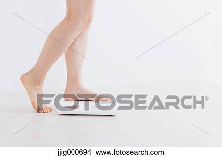 Woman riding on weight scale View Large Photo Image Picture - Woman riding on weight scale. Fotosearch