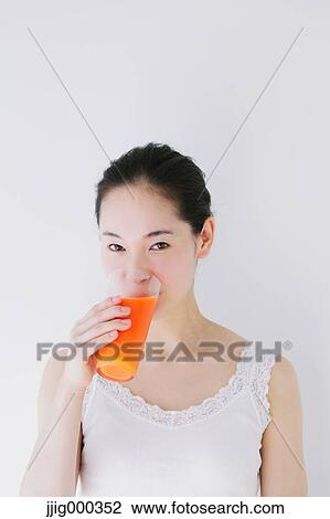 Young woman drinking vegetable juice View Large Photo Image Stock Image - Young woman drinking vegetable juice. Fotosearch