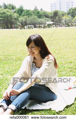Young woman on grassland smiling away View Large Photo Image Stock Image - Young woman on grassland smiling away. Fotosearch