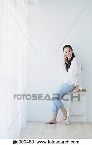 Young woman on the phone in the living room View Large Photo Image Stock Photo - Young woman on the phone in the living room. Fotosearch