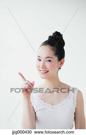 Young woman pointing finger up smiling View Large Photo Image Stock Image - Young woman pointing finger up smiling. Fotosearch