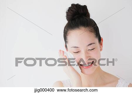 Stock Image - Young woman putting face-wash foam. Fotosearch