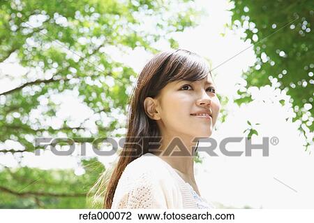 Young woman smiling away View Large Photo Image Stock Image - Young woman smiling away. Fotosearch