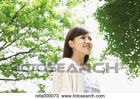 Stock Image - Young woman smiling away. Fotosearch
