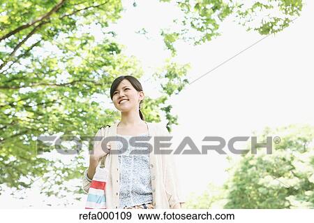 Young woman smiling away View Large Photo Image Stock Photo - Young woman smiling away. Fotosearch