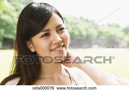 Young woman smiling away View Large Photo Image Stock Photograph - Young woman smiling away. Fotosearch