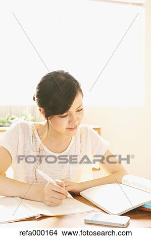 Young woman studying in the living room View Large Photo Image Picture - Young woman studying in the living room. Fotosearch