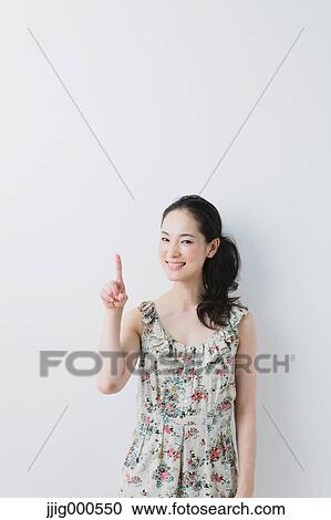Young woman wearing one piece pointing a finger View Large Photo Image Stock Image - Young woman wearing one piece pointing a finger. Fotosearch
