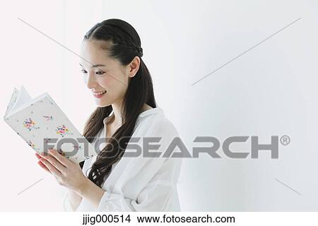 Picture - Young woman with book in the living room. Fotosearch