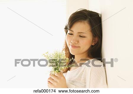 Picture - Young woman with flowers smiling. Fotosearch
