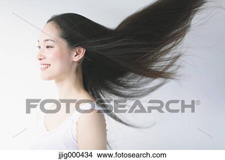 Young woman with fluttering hair smiling View Large Photo Image Picture - Young woman with fluttering hair smiling. Fotosearch